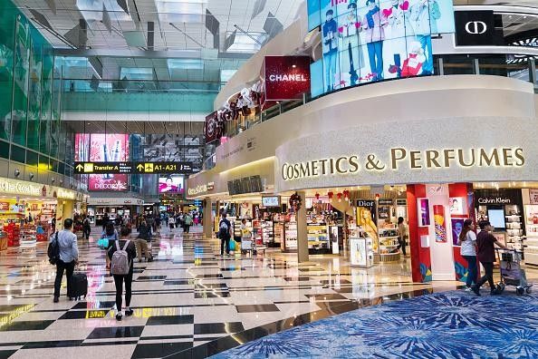 Travelers walk past stores at Terminal 3 (T3) of Changi Airport in Singapore.